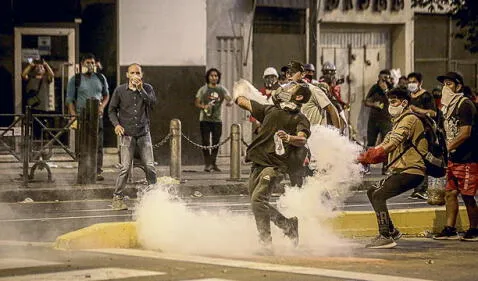 Respuesta. Manifestante en calle de Lima devuelve una bomba lacrimógena lanzada por la Policía. Foto: John Reyes/La República   