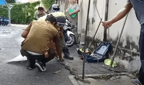 Desliza hacia la izquierda para ver las imágenes del video viral. Foto: Captura de YouTube. YouTube viral: enorme serpiente pitón queda atrapada en alcantarilla y pobladores se unen para rescatarla