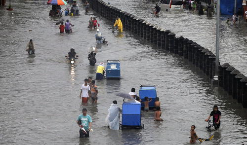 Filipinos caminan por calles inundadas en la ciudad de Las Pinas, al sur de Manila. El 12 de septiembre de 2017.
