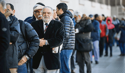 Colas. Personas hacen fila frente a un banco este martes. Colas. Personas hacen fila frente a un banco este martes.