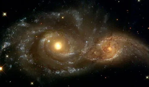 Representación artística de una gran galaxia engullendo a otra en su juventud | Foto referencial: NASA