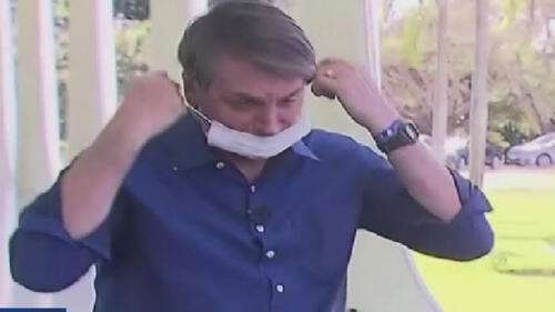 "Solo miren mi cara, estoy bien gracias a Dios", dijo Bolsonaro a los periodistas presentes mientras se retiraba la mascarilla. Foto: Captura video.