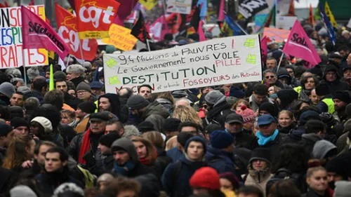 A demonstrator holds a sign reading "9,4 millions of poor, the government are looting us, dismissal" during a demonstration against the pension overhauls, in Paris, on December 5, 2019, as part of a national general strike. - Trains cancelled, schools closed: France scrambled to make contingency plans on for a huge strike against pension overhauls that poses one of the biggest challenges yet to French President's sweeping reform drive (Photo by Alain JOCARD / AFP) A demonstrator holds a sign reading "9,4 millions of poor, the government are looting us, dismissal" during a demonstration against the pension overhauls, in Paris, on December 5, 2019, as part of a national general strike. - Trains cancelled, schools closed: France scrambled to make contingency plans on for a huge strike against pension overhauls that poses one of the biggest challenges yet to French President's sweeping reform drive (Photo by Alain JOCARD / AFP)