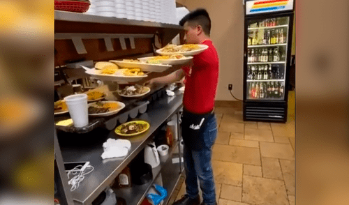 Mesero sorprende con la peculiar manera de llevar enormes platos usando solo un brazo