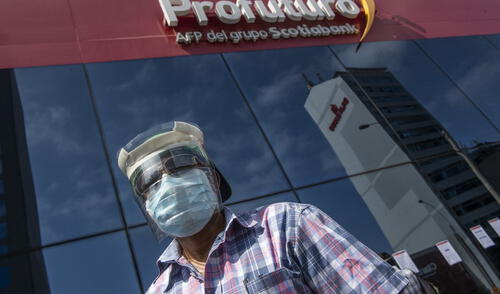 A man looks for information at the front door of Profuturo AFP (Pension Fund Administration) office in Lima on May 18, 2020. - More than six million Peruvians can request as of Monday the withdrawal of up to 3,700 US dollars from their pension funds to alleviate the economic crisis caused during the two months lockdown imposed by the government to fight the spread of the novel Covid-19 coronavirus. (Photo by ERNESTO BENAVIDES / AFP)