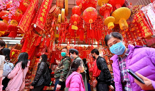La gente compra en un mercado que ofrece decoraciones y golosinas del Año Nuevo Lunar en Hong Kong el 17 de enero de 2021. Foto: AFP