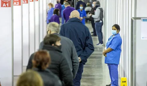members of the public wait to receive a dose of the AstraZeneca/Oxford Covid-19 vaccine at the SSE Arena which has been converted into a temporary vaccination centre, in Belfast, Northern Ireland on March 29, 2021. (Photo by Paul Faith / AFP)