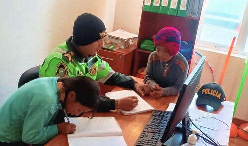 Suboficial de la PNP brinda clases de reforzamiento a dos hermanitos dentro de comisaría.