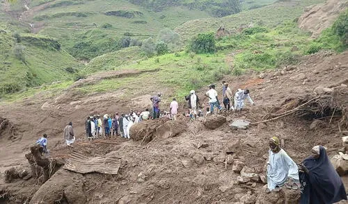 Personas inspeccionando los escombros tras un deslizamiento de tierra que devastó la aldea de Tarasin. Foto: AFP