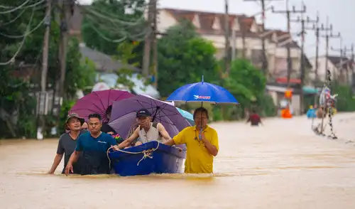 Personas cruzan aguas inundadas y son evacuadas en bote en Hat Yai, al sur de Tailandia, tras días de lluvias torrenciales. Foto: AFP