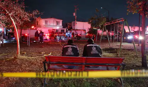 Empleados municipales permanecen frente a la casa donde se fabricaba pirotecnia clandestina y que explotó dejando tres muertos y seis heridos. Foto: AFP