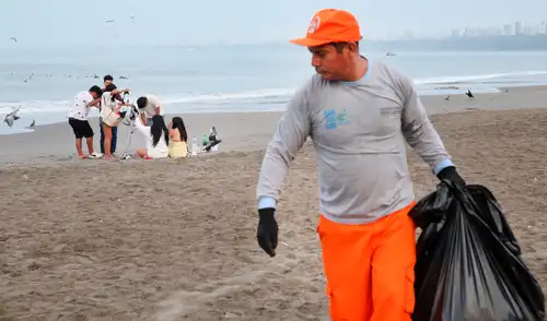 Mientras muchos bañistas llegan a las playas de Chorrillos, el personal de limpieza se retira luego de una ardua jornada laboral.