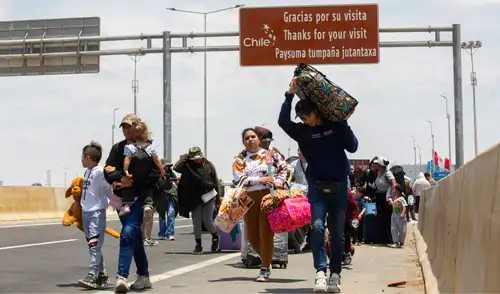 Migrantes caminan cerca del cruce fronterizo de Arica con Perú. Foto: AFP
