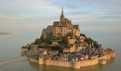 Mont Saint-Michel, en Normandía, Francia, es famoso por sus dramáticos cambios de paisaje causados por las mareas, que transforman su acceso y vista en cada visita.