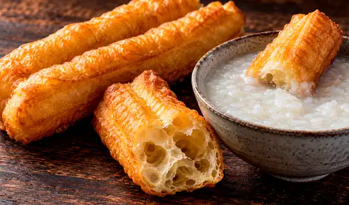 El youtiao es un desayuno tradicional chino que, aunque tiene un aspecto dorado similar al churro. Este plato destaca por su textura crocante y esponjosa.