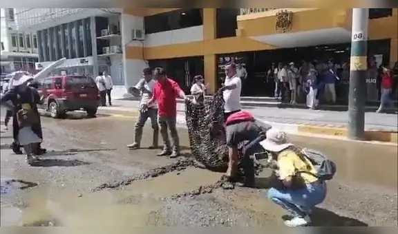 Ciudadanos protestan levantando la pista frente a la Municipalidad de Piura con sus manos
