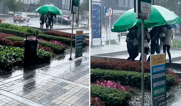 Trabajadores salen a almorzar y llevan enorme sombrilla para evitar mojarse ante intensa lluvia
