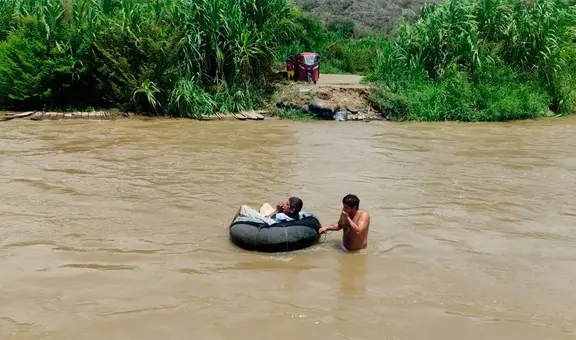 Niños y adultos mayores cruzan río sobre cámaras de llanta ante colapso de puente artesanal