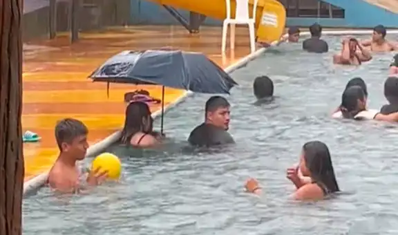 Captan a pareja usando un paraguas dentro de la piscina al ser sorprendidos por intensa lluvia y le dicen: “Cuidado y se mojan”