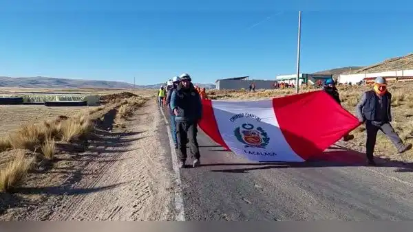 Obreros pausaron un momento el trabajo para marchar por el Día de la Bandera en Puno
