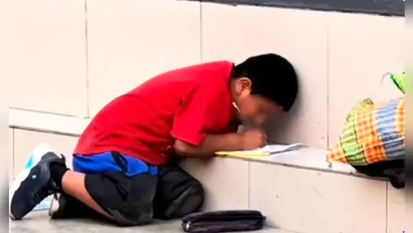 Captan a niño realizando su tarea en plena calle de Chincha, mientras su mamá trabaja como vendedora en semáforos
