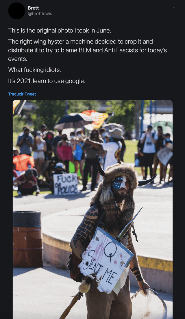 Fotografía original muestra a Jake Angeli sosteniendo un cartel que dice "Q me envió". Foto: captura en Twitter / @brettlewis