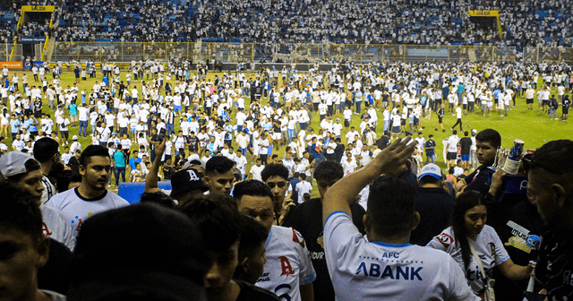  El Salvador: aficionados invaden la cancha luego de una estampida durante un partido de fútbol. Foto: AFP    