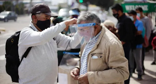 Ciudadanos ayudaron a adultos mayores a colocarse el protector facial. Foto: Rodrigo Talavera / La República.