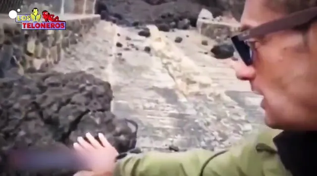 Al tocar la piedra volcánica, el reportero retiró instantáneamente su mano y la agitó del dolor. Foto: Captura de video de Cuatro.com