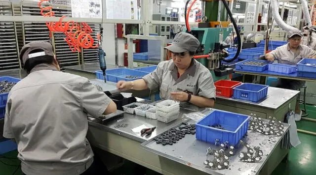 Empleados realizan ajustes en chips y metales en una empresa en China. Foto: EFE