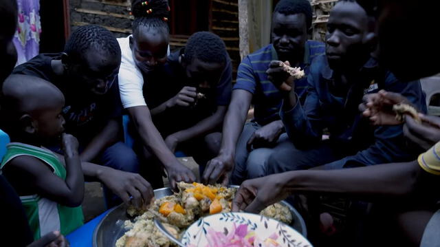 Toda la familia sudanesa disfrutó del arroz con pollo, hasta los niños. Foto: Pasaje en Mano/Youtube    