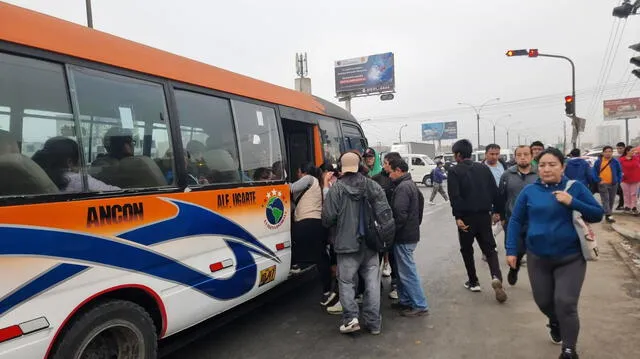 Panorama en primera de Pro. Pasajeros abordan buses de transporte público. 