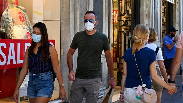 Personas con mascarilla caminan por la principal calle comercial Via del Corso el 20 de agosto de 2020 en Roma.