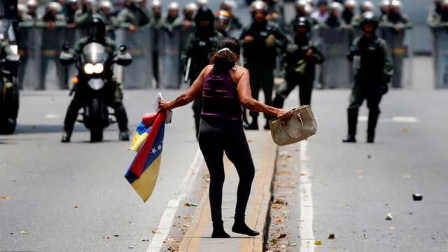 Una mujer en medio de una represión ejecutada por militares leales al régimen de Maduro. Foto: La Vanguardia.