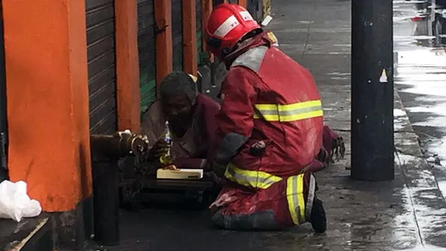 Bombero paraliza sus labores para regalarle comida a indigente [FOTOS]