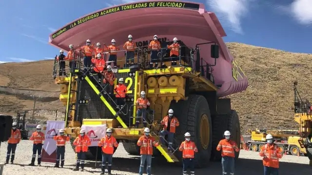 Trabajadores posan en el camión minero de grandes dimensiones.