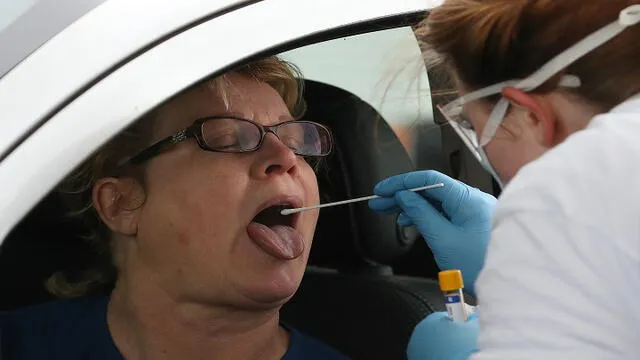 Realizan test para detectar el coronavirus a una mujer dentro de su vehículo. Foto: AFP.en