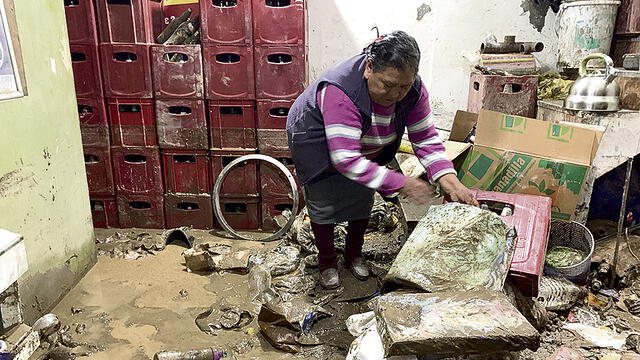 Pérdidas. Madre de Christian Cayro ayuda a limpiar el desastre que causó el ingreso del huaico en su vivienda.
