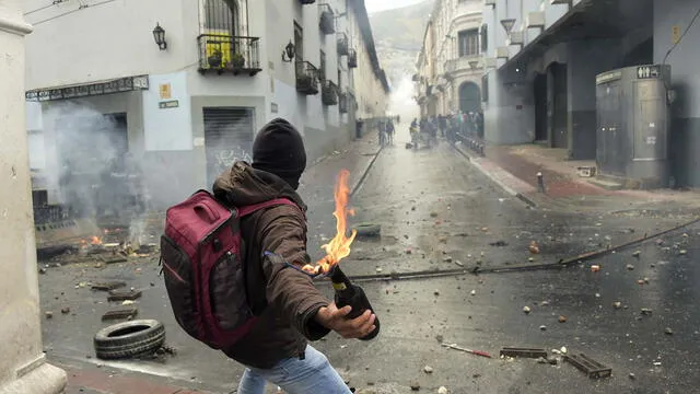 Un manifestante, en Quito, se prepara para lanzar un cóctel molotov a la policía tras el anuncio de una huelga contra las políticas económicas del presidente ecuatoriano Lenin Moreno