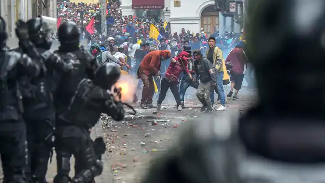 Los manifestantes se enfrentan con la policía antidisturbios en una de las calles de Quito.