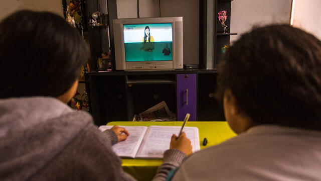 Unos niños siguen una clase virtual desde casa, en Lima (Perú). ¿Qué hacer si hay infectados de coronavirus en casa? Foto: Victor Idrogo / Iconica