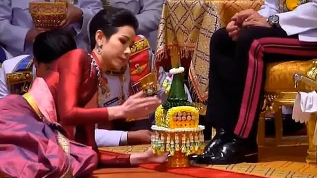 Concubina Sineenat Wongvajirapakdi se rinde ante el reyde Tailandia para recibir su título. Foto captura YouTube.
