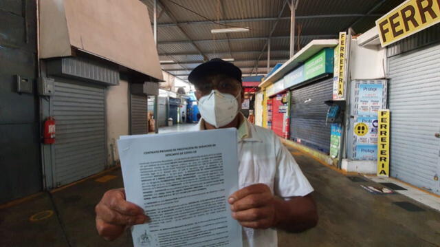 Florentino Pino sostiene el contrato con un centro médico que garantiza la atención en el mercado está libre de infectados con Covid-19. Foto: Joel Robles.