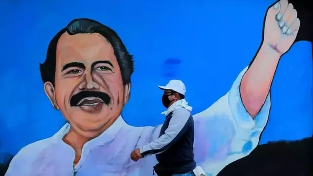 Un hombre con un tapabocas pasa por delante del retrato mural del presidente Daniel Ortega. (Foto: Oswaldo Rivas/Reuters)