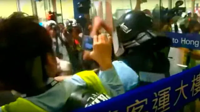 Momento en que manifestantes arrinconan y golpean a policía. Captura de video/CNA.