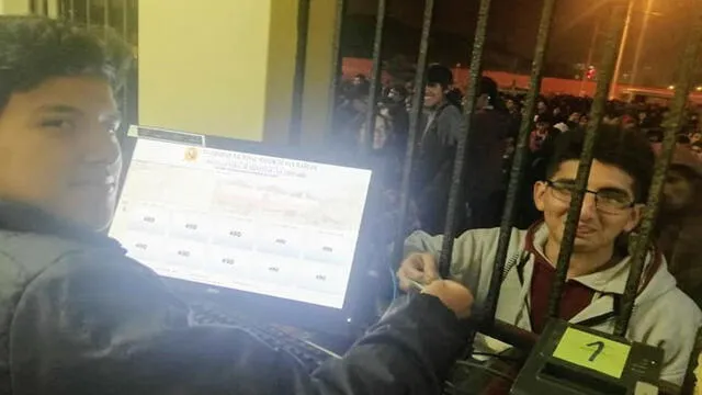El preciso instante en el que controlador le entrega el primer ticket a Aaron Quispe. (Foto: Facebook UNMSM)