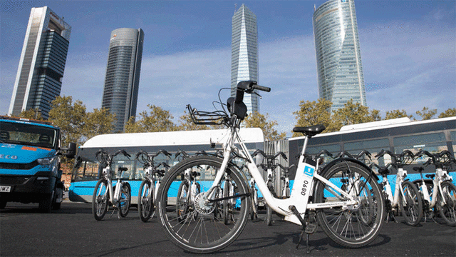 Varias bicicletas del servicio BiciMAD frente a las cuatro torres de Madrid. (Ayuntamiento de Madrid).