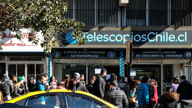 Varias personas asisten a comprar gafas especializadas para ver el eclipse solar en Santiago de Chile. Foto: EFE.