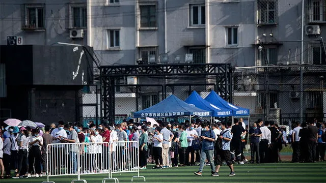 Cientos de personas en un centro deportivo para hacerse pruebas. Foto: AFP.