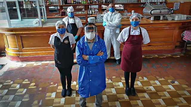 Jacinto Lopez, dueño del bar Cordano, junto a sus trabajadores armados con mascarillas, guantes, protectores faciales y alcohol. (Foto: Viviana Ortiz)